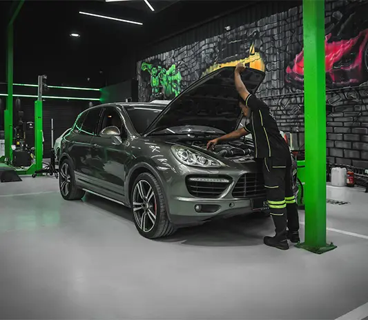 a mechanic is fixing the Porsche car