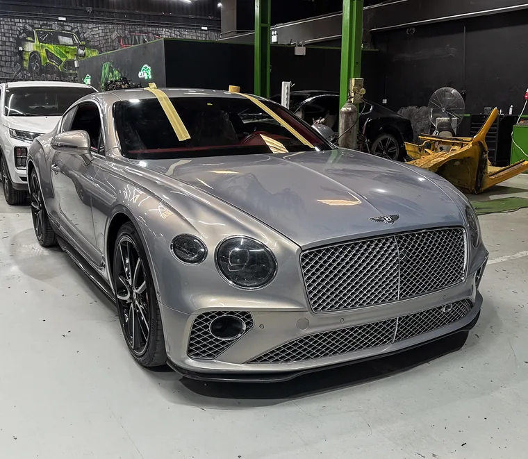 Silver Bentley Continental GT in a service bay at the Exotic Auto Services workshop in Mussafah, Abu Dhabi.