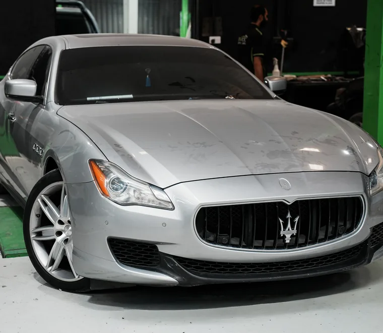 Silver Maserati Quattroporte in a service bay at the Exotic Auto Services workshop in Mussafah, Abu Dhabi.