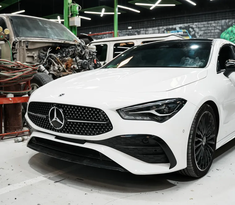 White Mercedes-Benz CLA four-door coupe inside the Exotic Auto Services workshop in Mussafah, Abu Dhabi.