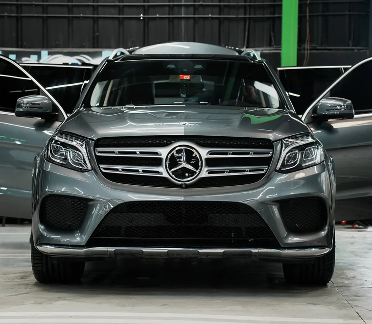 Grey Mercedes-Benz SUV with its doors open during a front-end inspection at Exotic Auto Services in Abu Dhabi.