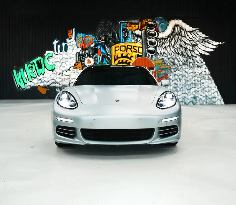 White Porsche Panamera in a service bay at the Exotic Auto Services workshop in Abu Dhabi.