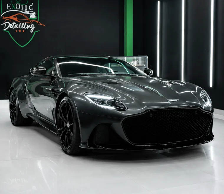 Dark Aston Martin DBS photographed from the front quarter after service at the Mussafah workshop.