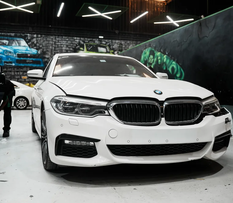 White BMW 5 Series M Sport in a service bay at Exotic Auto Services in Mussafah, Abu Dhabi.