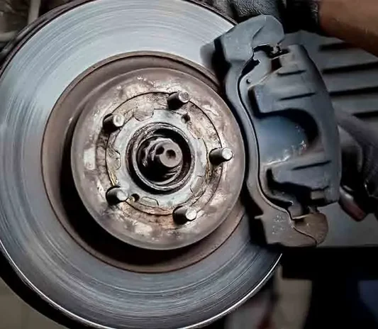 Brake disc and calliper during a brake repair at the Exotic Auto Services workshop in Mussafah, Abu Dhabi