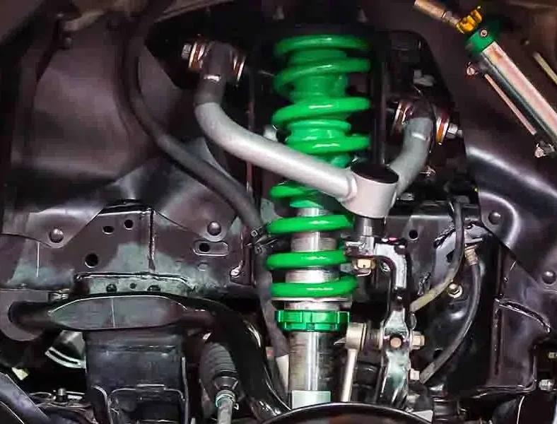 Car suspension coil spring and shock absorber assembly during a suspension repair at the Exotic Auto Services workshop in Mussafah, Abu Dhabi