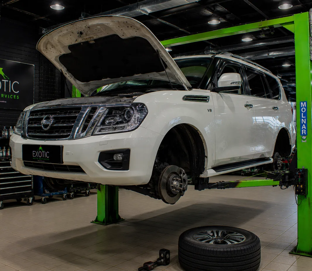 Nissan with the wheels off for brake service at the Mussafah workshop