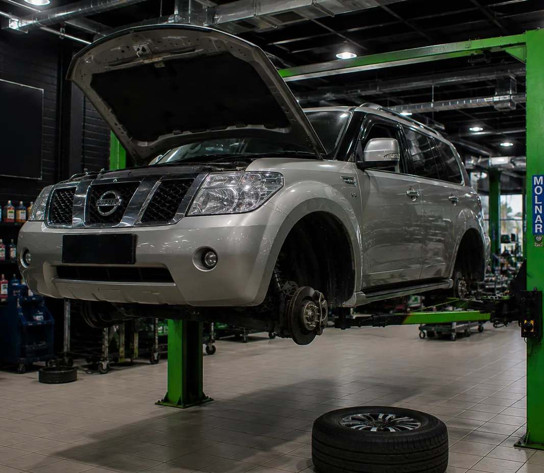 Nissan raised on the two-post lift at the Exotic Auto Services workshop in Mussafah
