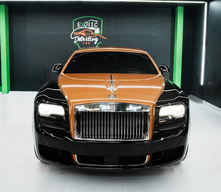 Two-tone orange and black Rolls-Royce photographed head-on in a service bay at Exotic Auto Services, Abu Dhabi.